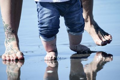 Low section of toddler learning to walk on the beach