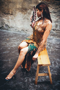 Midsection of woman sitting on seat