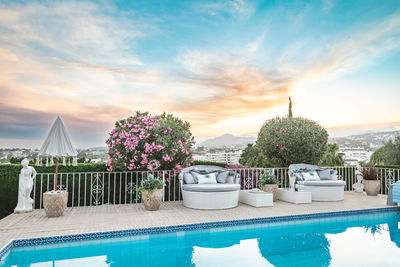 A pair of seashell style outdoor sofas surrounding a swimming pool along the costa del sol close up