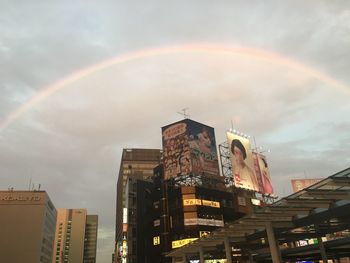 Low angle view of rainbow over city against sky