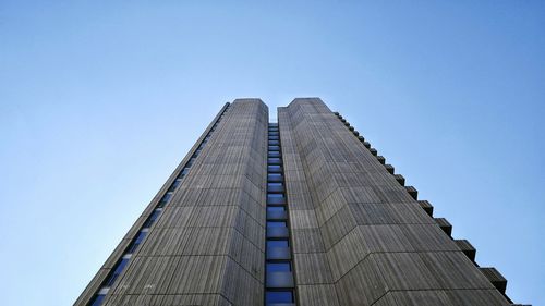 Low angle view of skyscraper against clear blue sky