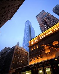 Low angle view of skyscrapers against blue sky