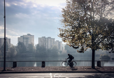 Bicycle by cityscape against sky