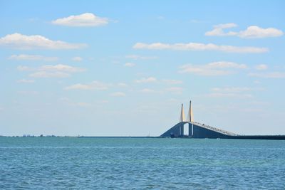 Suspension bridge over sea against sky