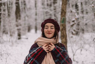 Beautiful young woman enjoying a wonderful winter day in the forest