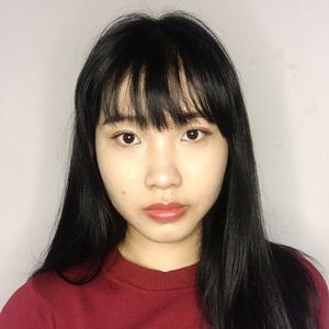 Close-up portrait of young woman against wall