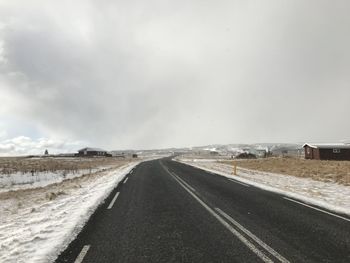 Country road against sky during winter