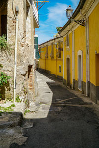 Empty road along buildings