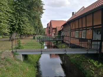 Buildings by river against sky