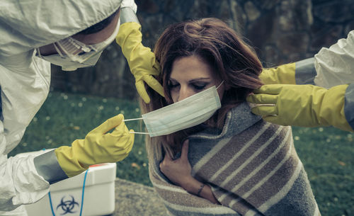 Man and woman with pollution mask helping female during corona outbreak