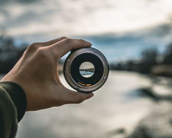 Close-up of hand holding camera lens