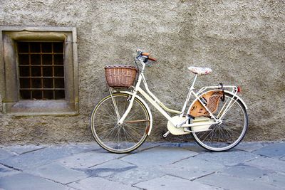 Bicycle parked against brick wall