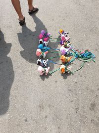 Low section of woman standing by toys on footpath