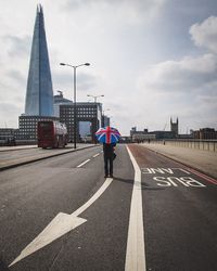 Man with london flag umbrella walking on street