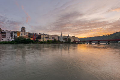 View of buildings at waterfront against cloudy sky