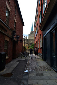 Rear view of man walking on street in city