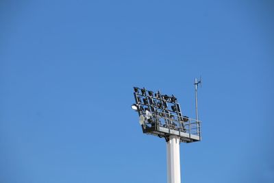 Low angle view of floodlight against clear blue sky