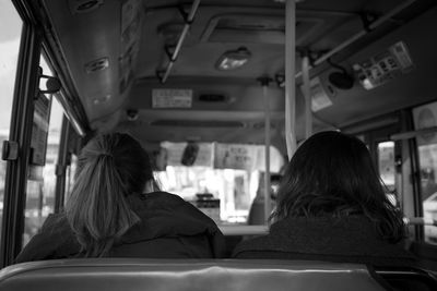 Rear view of woman sitting in train