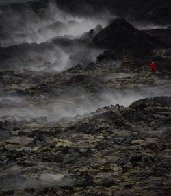 Woman hiking through the lava field at krafla volcano