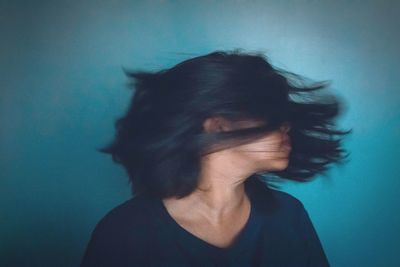 Close-up of woman against blue background