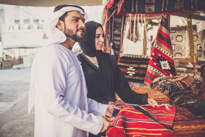 Couple buying clothing at market