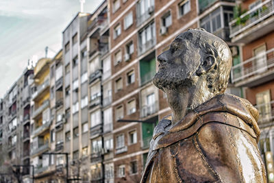 Low angle view of statue against building in city