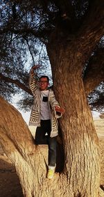 Man holding umbrella against trees