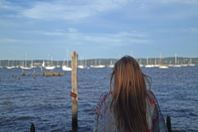 Rear view of woman overlooking calm sea