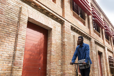 Full length of man standing against building