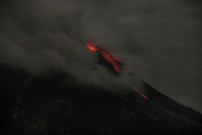 Light trails on mountain against sky