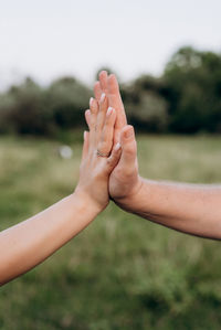 Cropped image of couple giving high five against blurred background