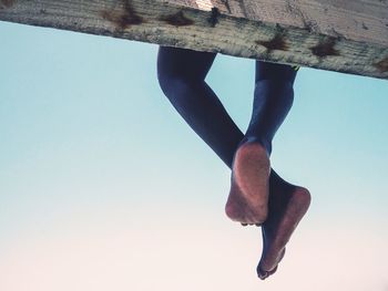 Low section of woman against clear blue sky