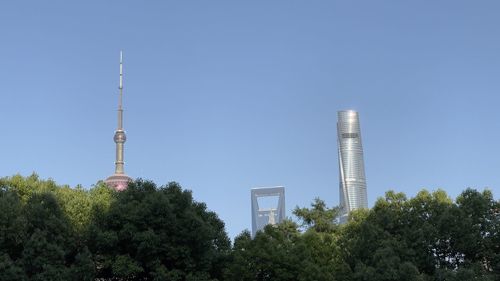 Low angle view of trees and buildings against sky