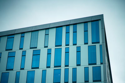 Low angle view of modern building against clear blue sky