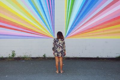 Rear view of woman standing against rainbow