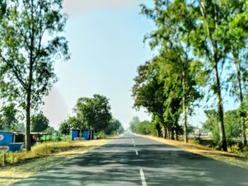 Road amidst trees against sky