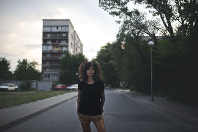 Young woman standing on road in city