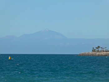 Scenic view of sea against clear blue sky