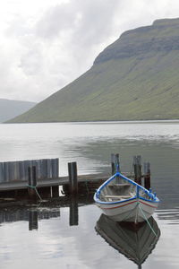 Boat moored in lake against sky