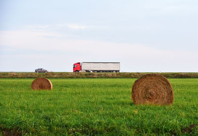 Hay bales on field against sky