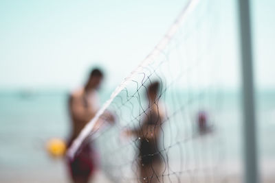 Close-up of man by sea against clear sky