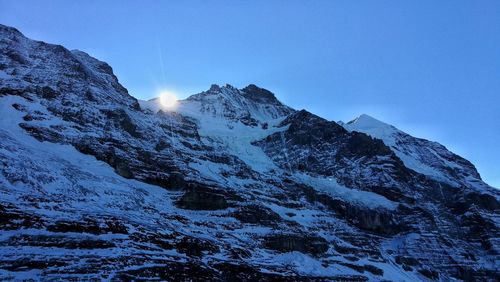 Scenic view of snowcapped mountains against blue sky