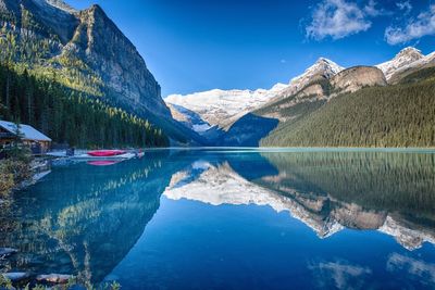 Scenic view of lake and mountains against blue sky