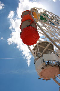 Low angle view of ferris wheel against cloudy sky