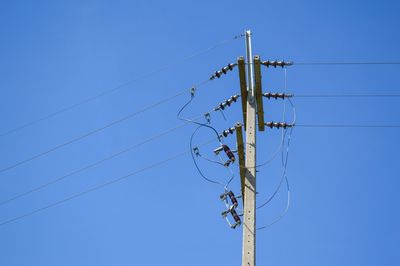 Low angle view of telephone line against clear blue sky