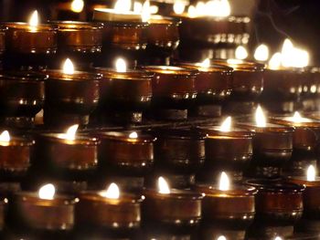 Close-up of lit candles in row