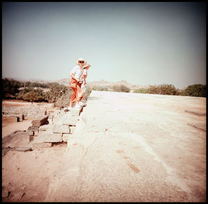 Men standing on ground against clear sky