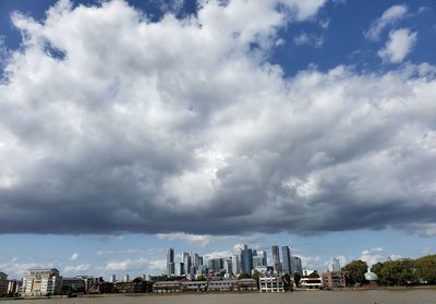 Buildings in city against cloudy sky