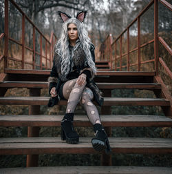 Portrait of young woman sitting on staircase