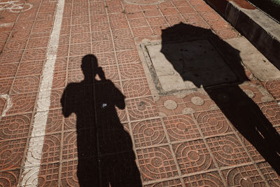 High angle view of man shadow on floor in city